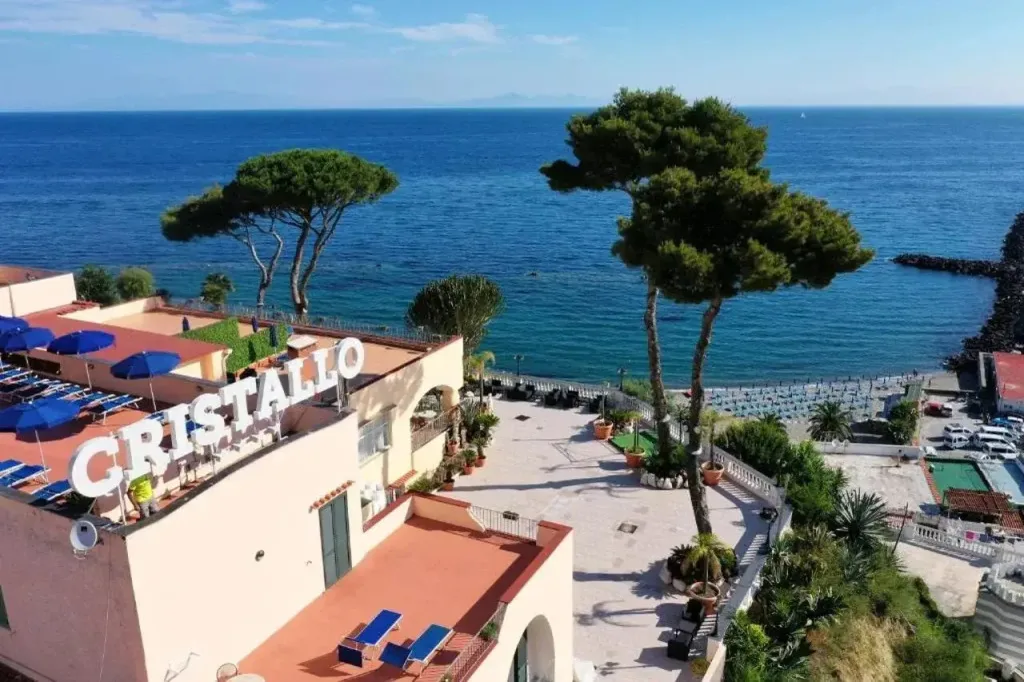 Vista panoramica dell'Hotel Cristallo con terrazza, pini e mare sullo sfondo