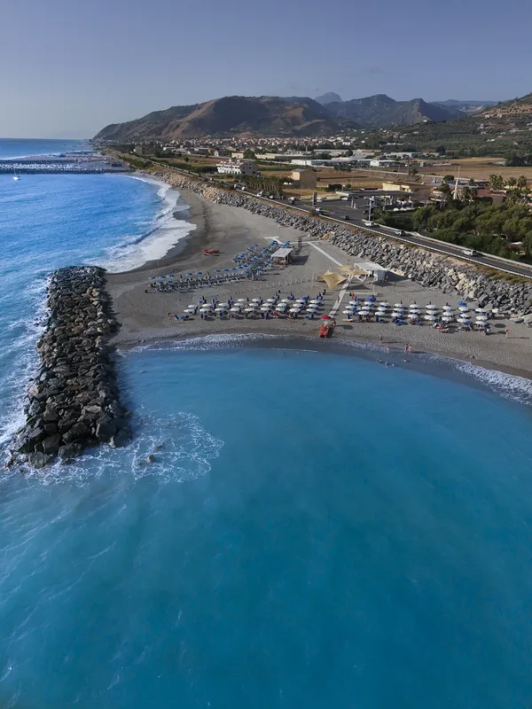 Veduta aerea della spiaggia attrezzata con ombrelloni e mare turchese