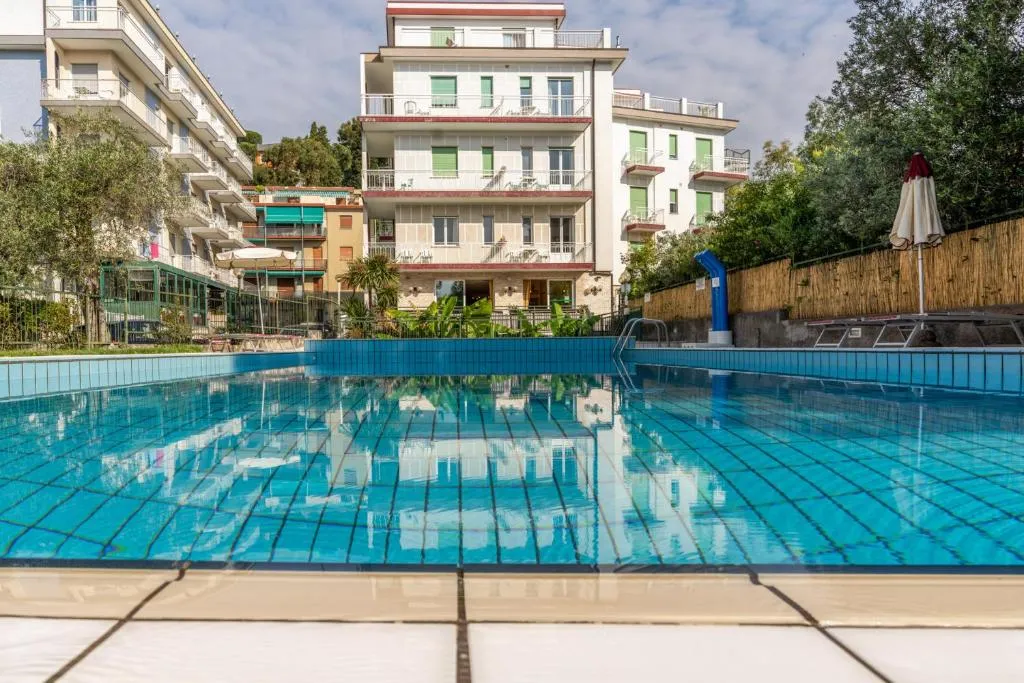 Piscina esterna con vista sull'edificio dell'hotel e giardino circostante