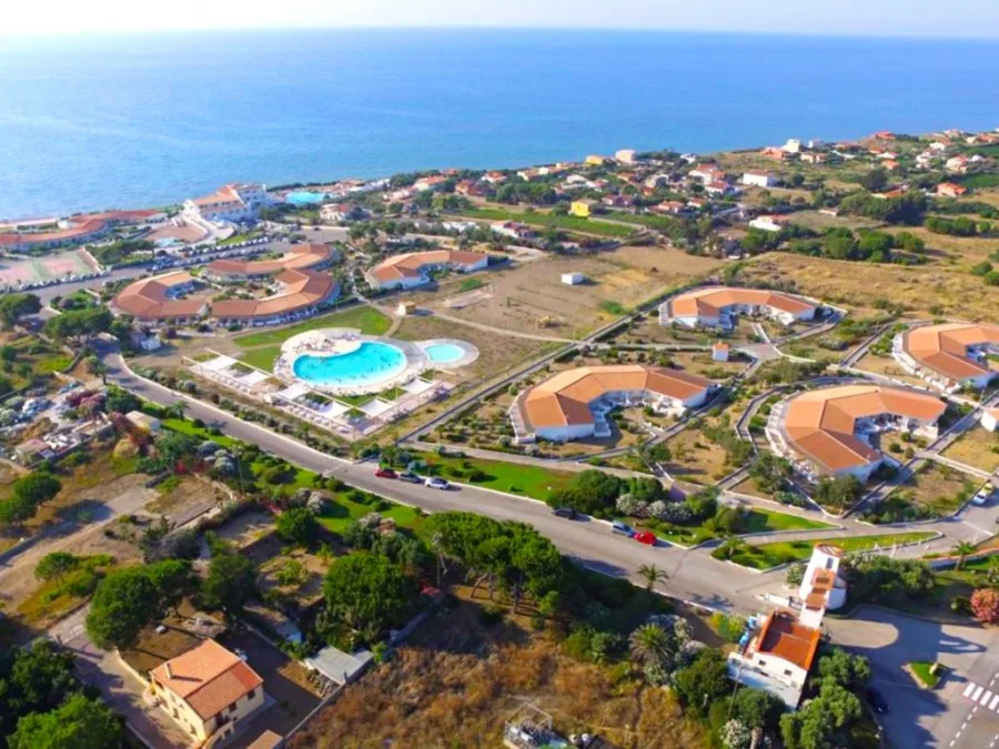Veduta aerea del complesso turistico con piscina e ville vicino al mare