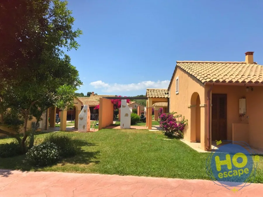 Villette del resort con tetti in coppi, giardino curato e bouganville fiorita
