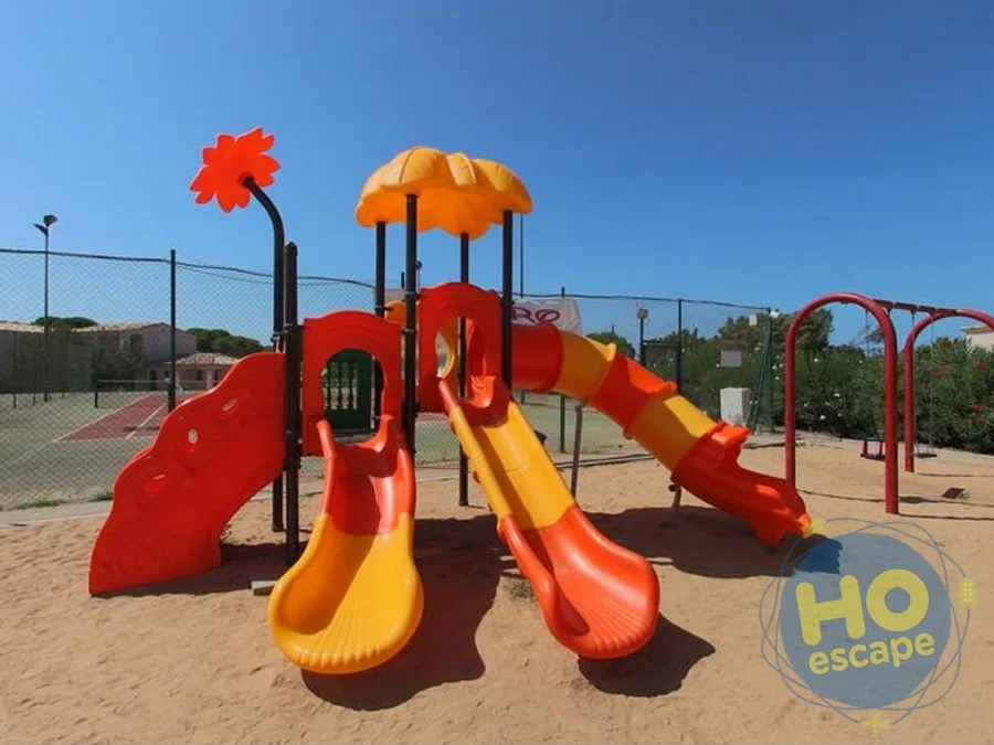 Parco giochi per bambini con scivoli colorati su sabbia