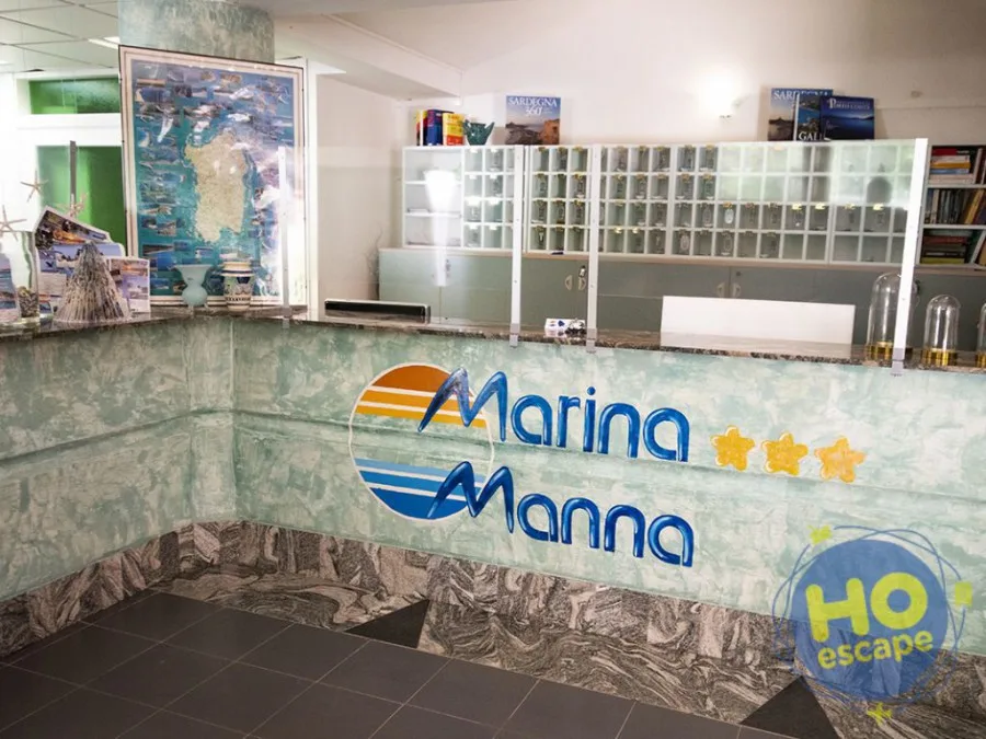 Reception dell'hotel Marina Manna con bancone in marmo e mappa della Sardegna