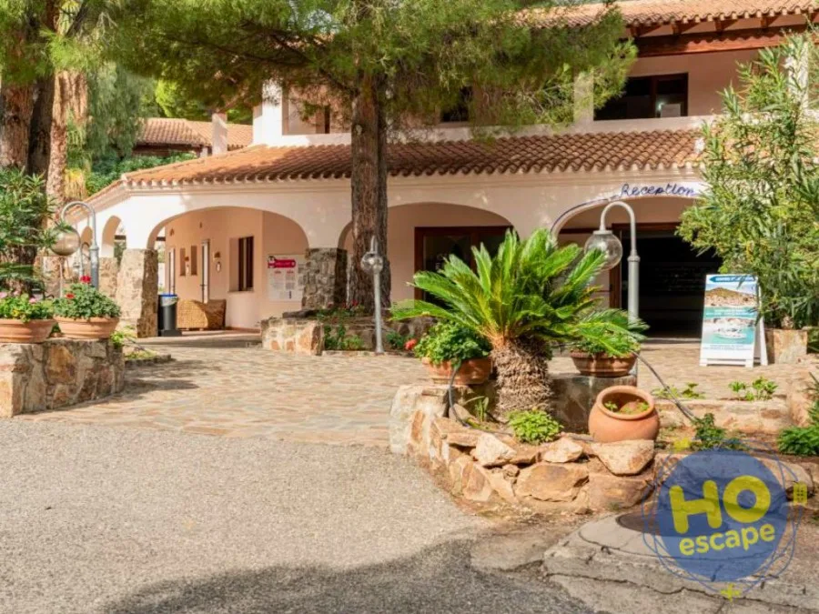 Ingresso della reception del resort con piante in vaso e archi in stile mediterraneo