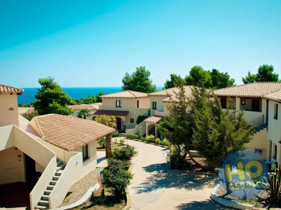 Villette del resort immerse nel verde con vista sul mare in lontananza