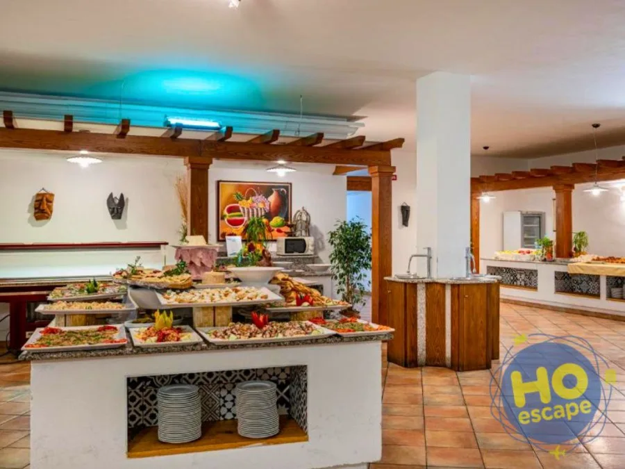 Sala buffet interna con isola centrale di pietanze, struttura in legno e pavimento in cotto