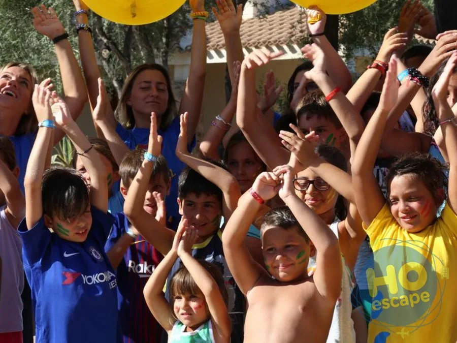 Gruppo di bambini con le braccia alzate durante l'animazione all'aperto