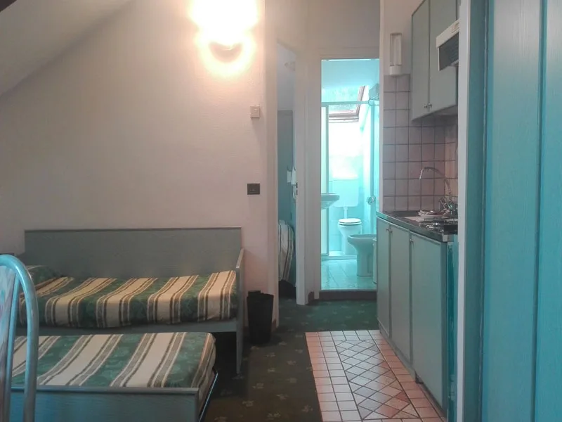 Monolocale con letti singoli, angolo cottura e bagno sul fondo