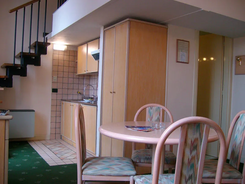 Appartamento su due livelli con scala a chiocciola, angolo cottura e tavolo da pranzo