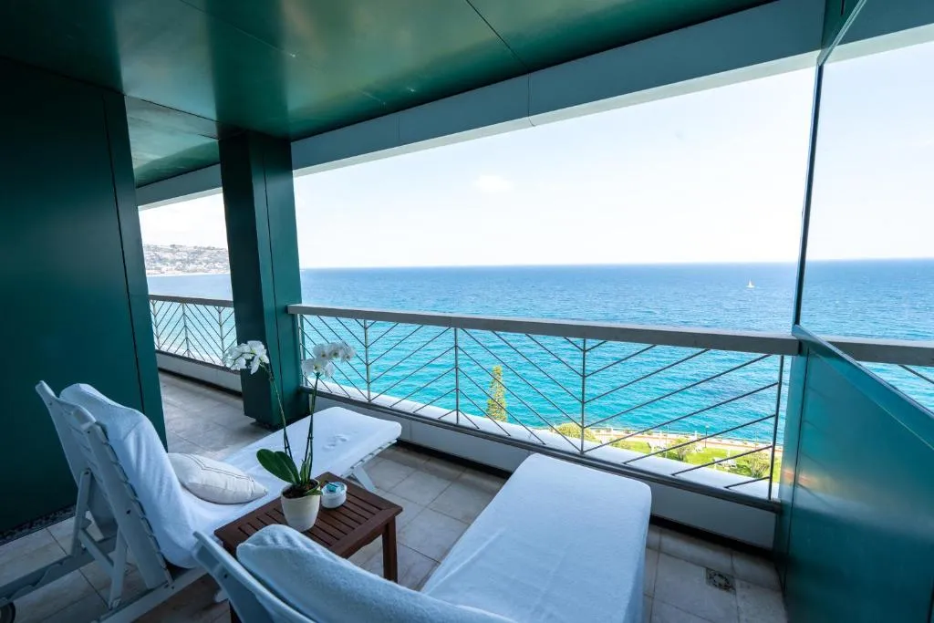 Balcone con lettini e vista panoramica sul mare turchese e la costa
