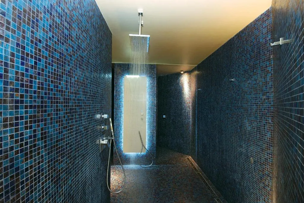Doccia emozionale con mosaico blu e cascata d'acqua illuminata