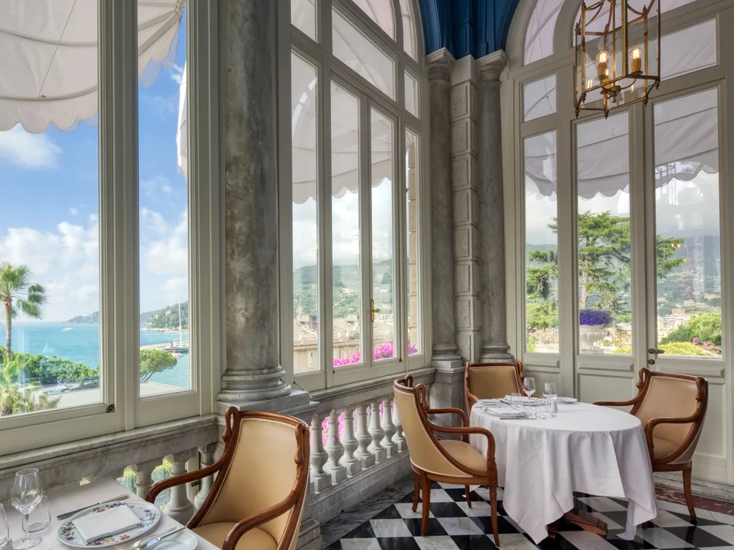 Sala ristorante interna con grandi vetrate, colonne in marmo e vista sul mare