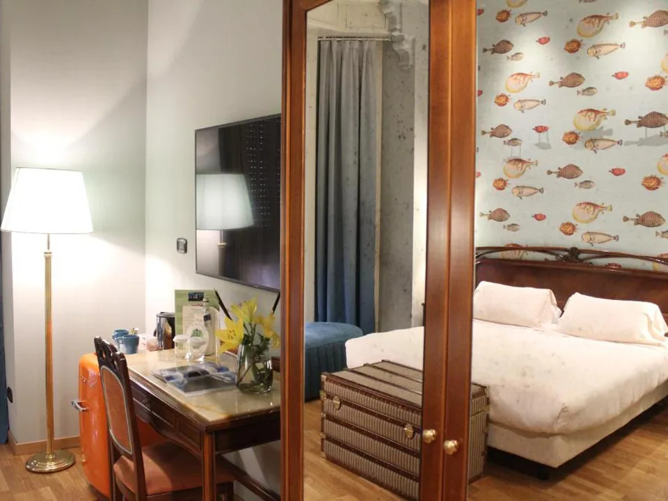 Camera con scrivania, specchio e carta da parati a tema pesci dietro al letto