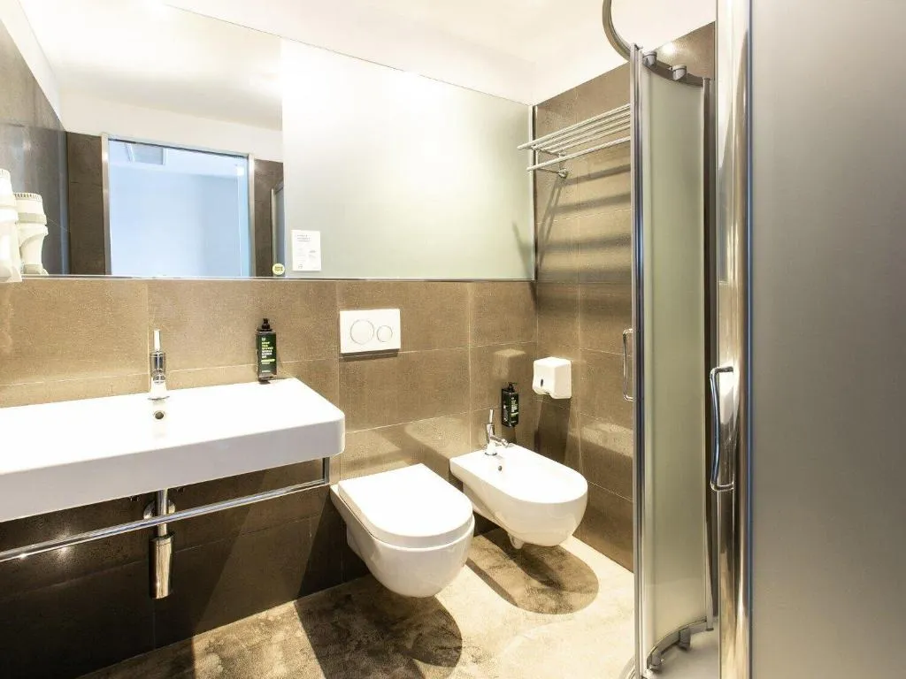Bagno moderno con lavabo, WC, bidet e doccia con piastrelle marroni