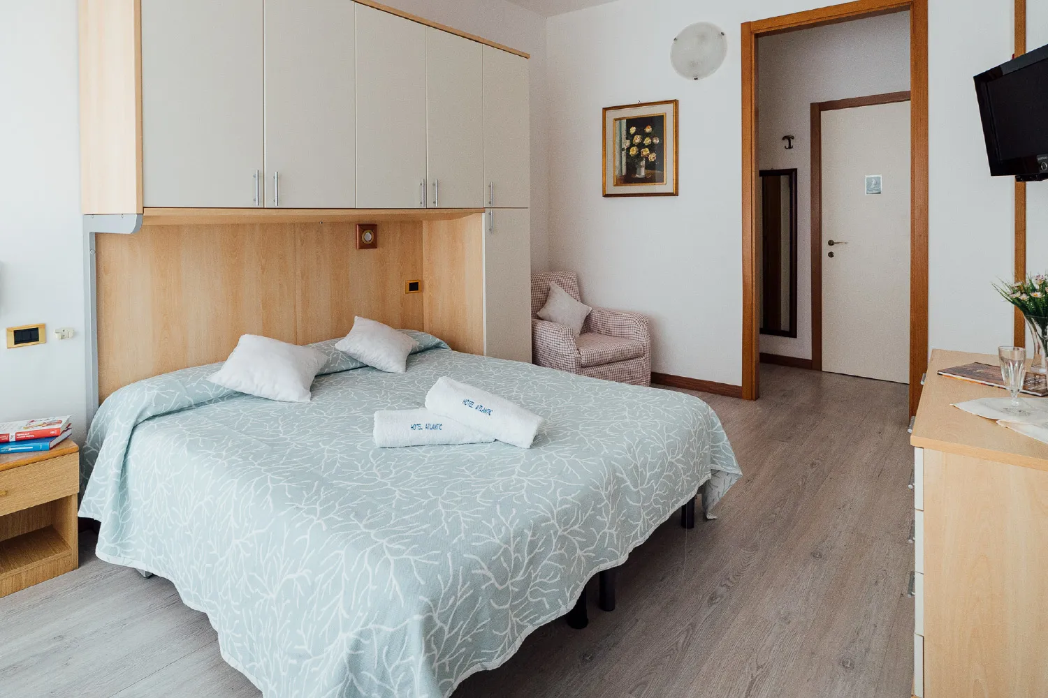 Camera spaziosa con letto, armadio, poltrona e parquet