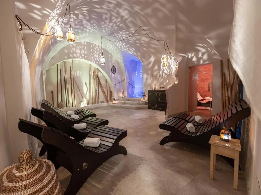 Zona relax della spa con lettini in legno, lanterne e atmosfera in stile orientale