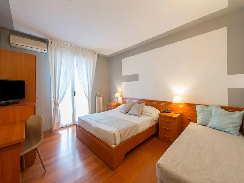 Camera con letto matrimoniale e singolo, scrivania e TV