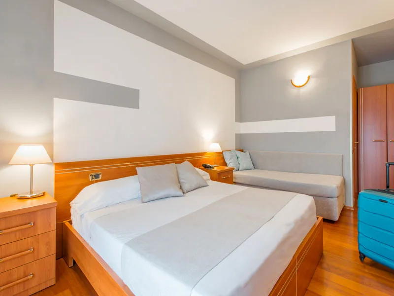 Camera matrimoniale con divano, parquet e arredo in legno