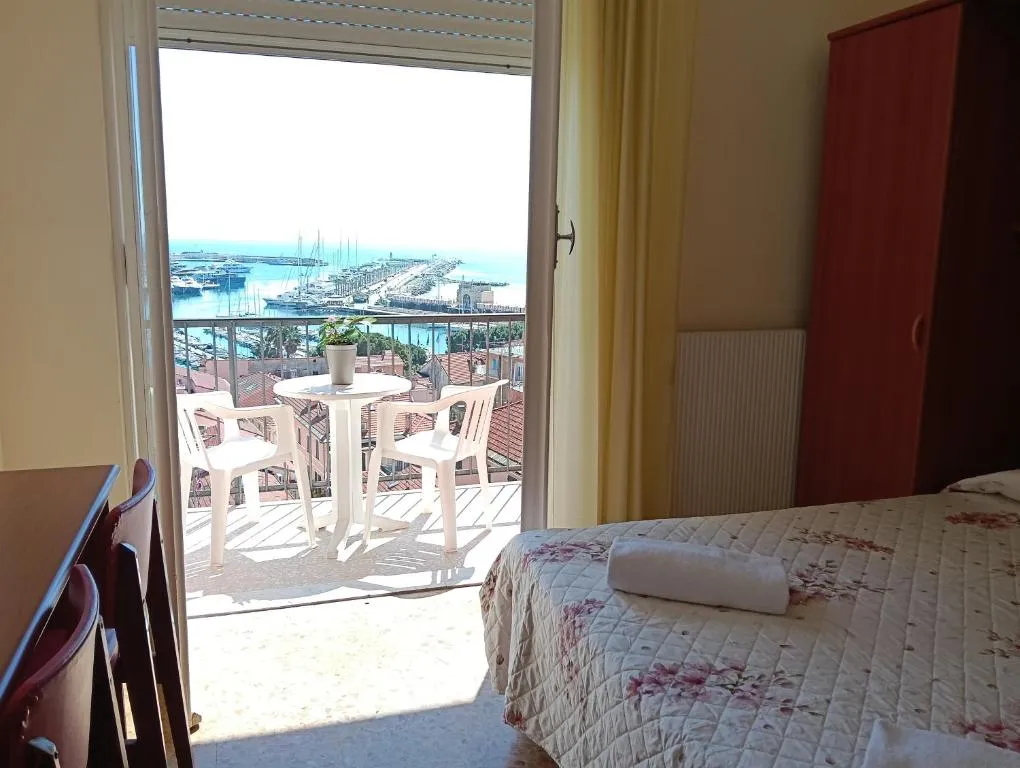 Camera con letto e balcone affacciato sul porto e sul mare