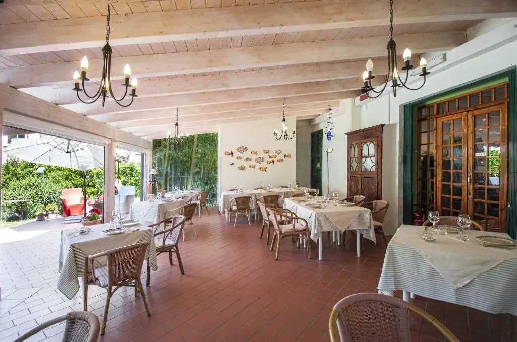 Sala ristorante coperta con tavoli apparecchiati e soffitto in legno