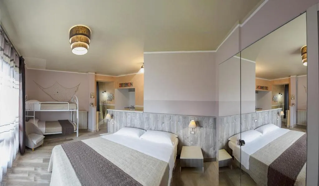 Camera familiare con letto matrimoniale, letti a castello e specchio a parete