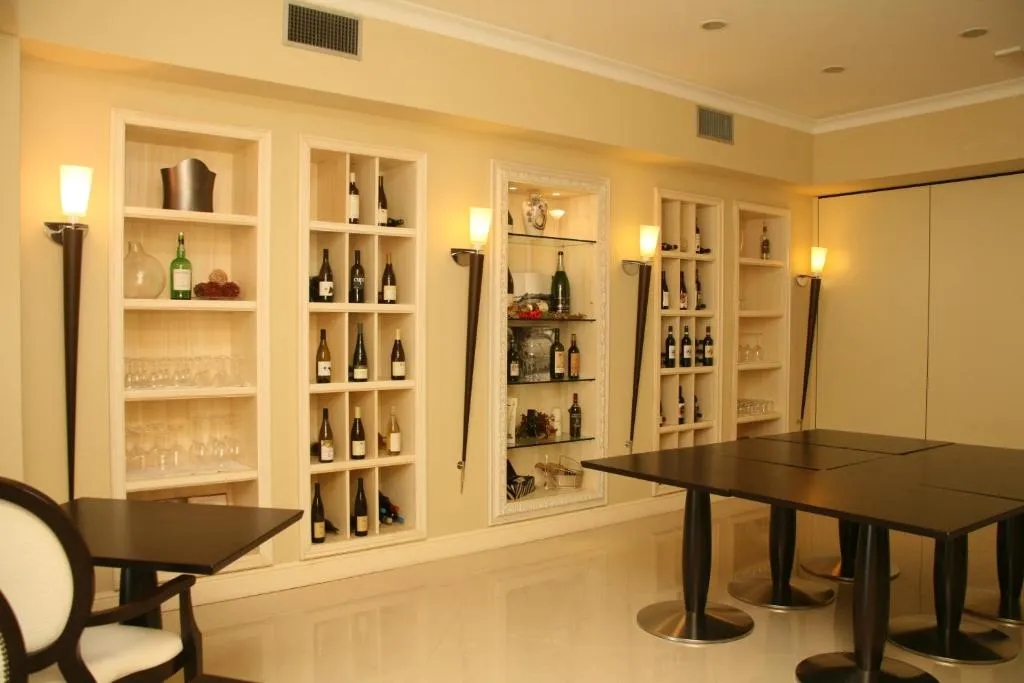 Sala con scaffalature espositive di vini, tavoli scuri e illuminazione soffusa