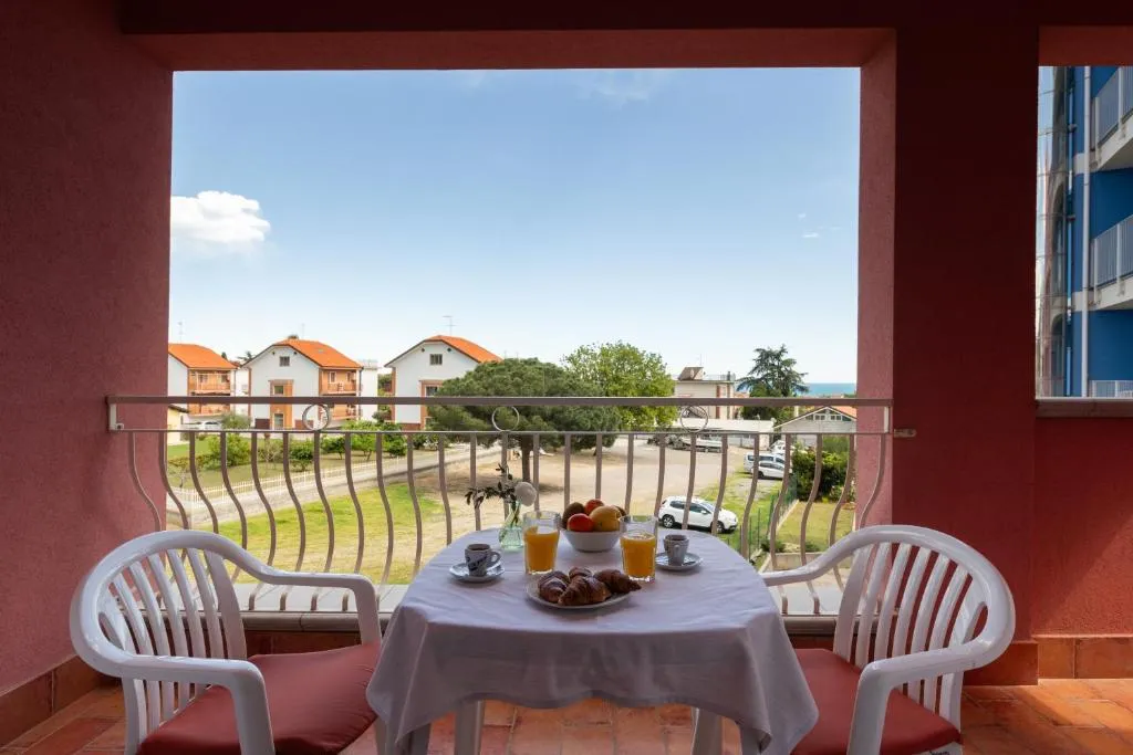 Balcone con tavolo apparecchiato per colazione e vista sul giardino