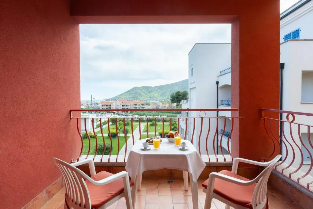 Balcone con colazione e vista panoramica su montagne e residence
