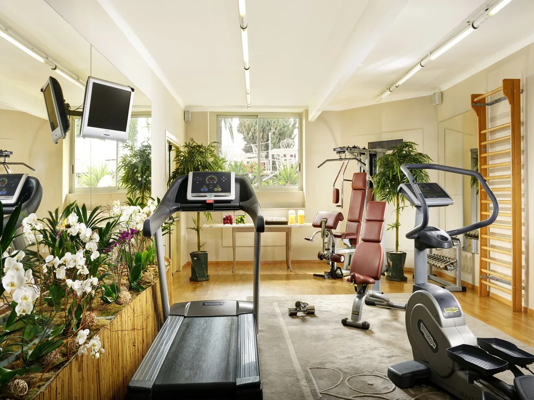 Palestra attrezzata con tapis roulant, macchinari fitness e piante decorative