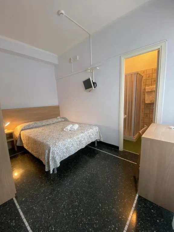Camera matrimoniale con TV a parete, pavimento in marmo e bagno annesso