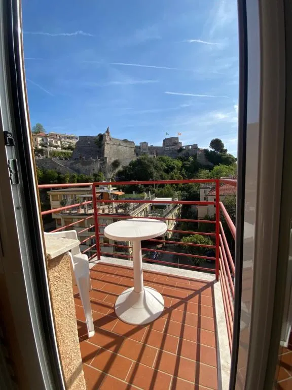Vista dal balcone su castello in collina con tavolino e cielo azzurro