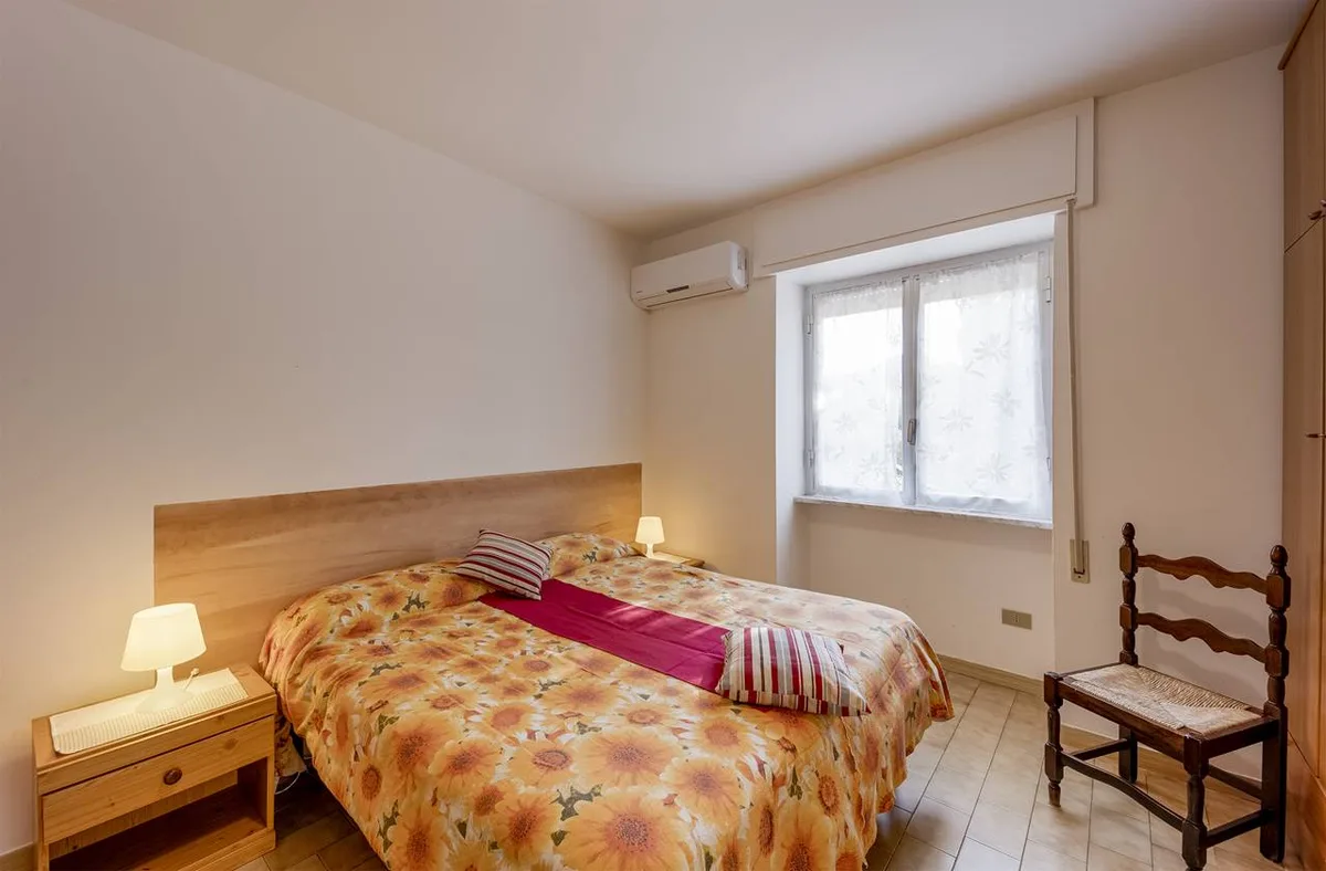 Camera da letto matrimoniale con copriletto floreale e aria condizionata