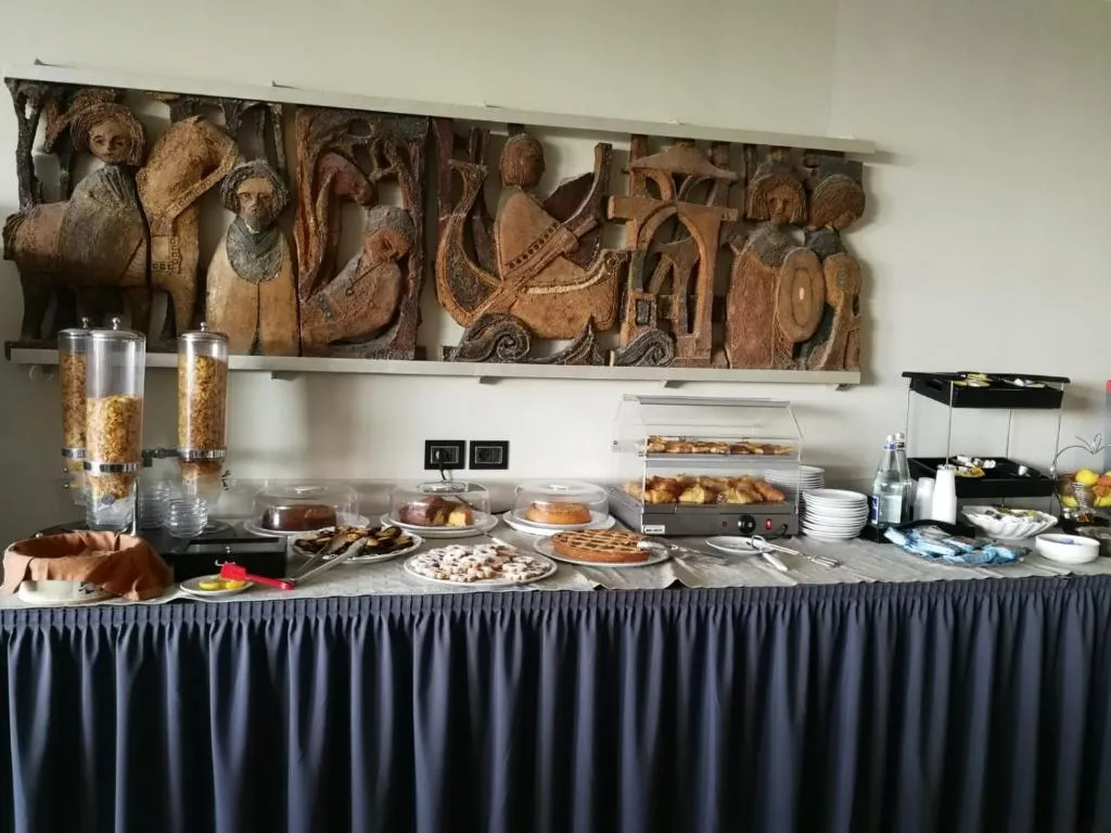 Buffet della colazione con dolci, crostate, cereali e pannello decorativo