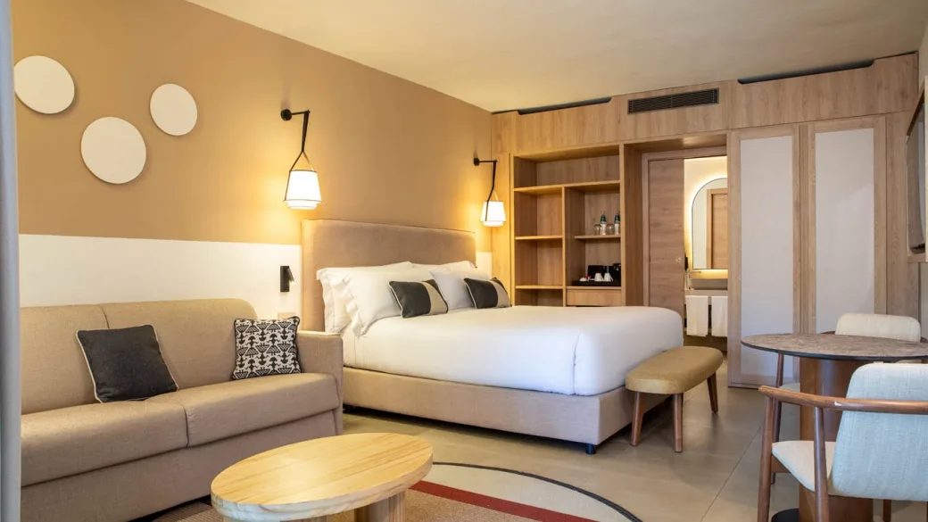 Camera spaziosa con letto matrimoniale, divano, scrivania e bagno comunicante