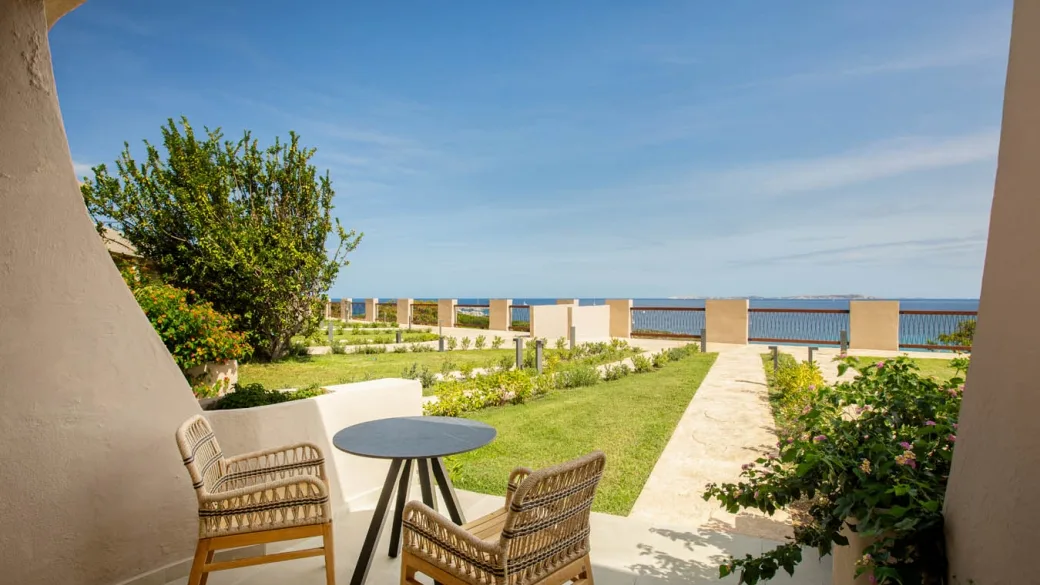 Terrazza privata della camera con tavolino, sedie in rattan e vista sul mare