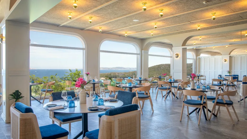 Elegante sala ristorante con grandi finestre ad arco e vista panoramica sul mare