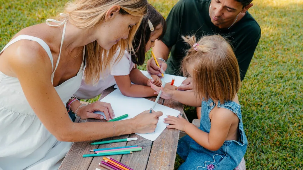 Famiglia che disegna insieme a un tavolo da picnic nel giardino