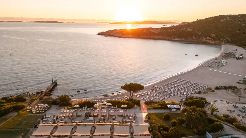 Veduta aerea della spiaggia e del resort al tramonto con cielo dorato