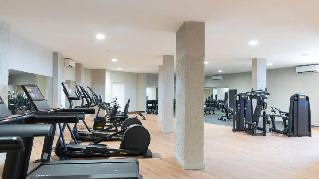 Palestra attrezzata con tapis roulant, macchinari e pavimento in legno