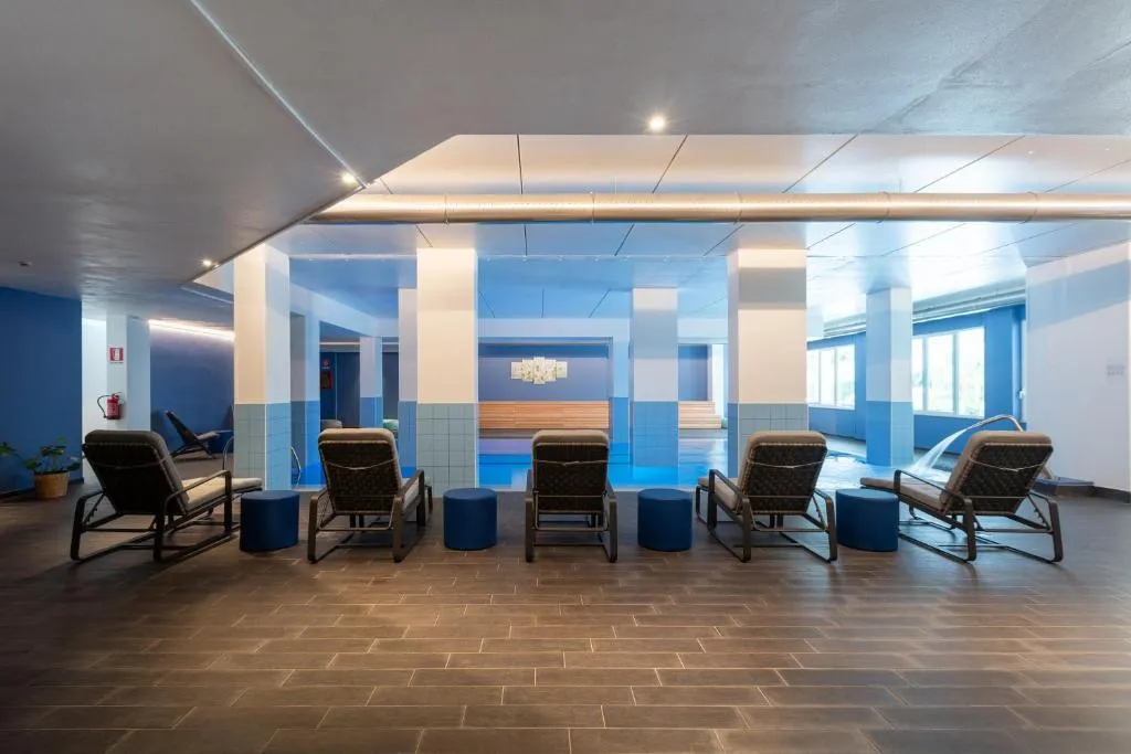 Area relax con piscina interna coperta, lettini e pareti blu